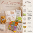 Load image into Gallery viewer, Sweet Beginnings Baby Gift Set displayed on a beige fabric surface with a teddy bear, white knit blanket, baby wipes, swabs, socks, spoons, books, and accessories. A vertical inset list on the right details what is included.
