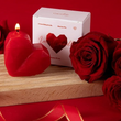 Load image into Gallery viewer, Heart-shaped candle and box with red roses on a wooden surface against a red background
